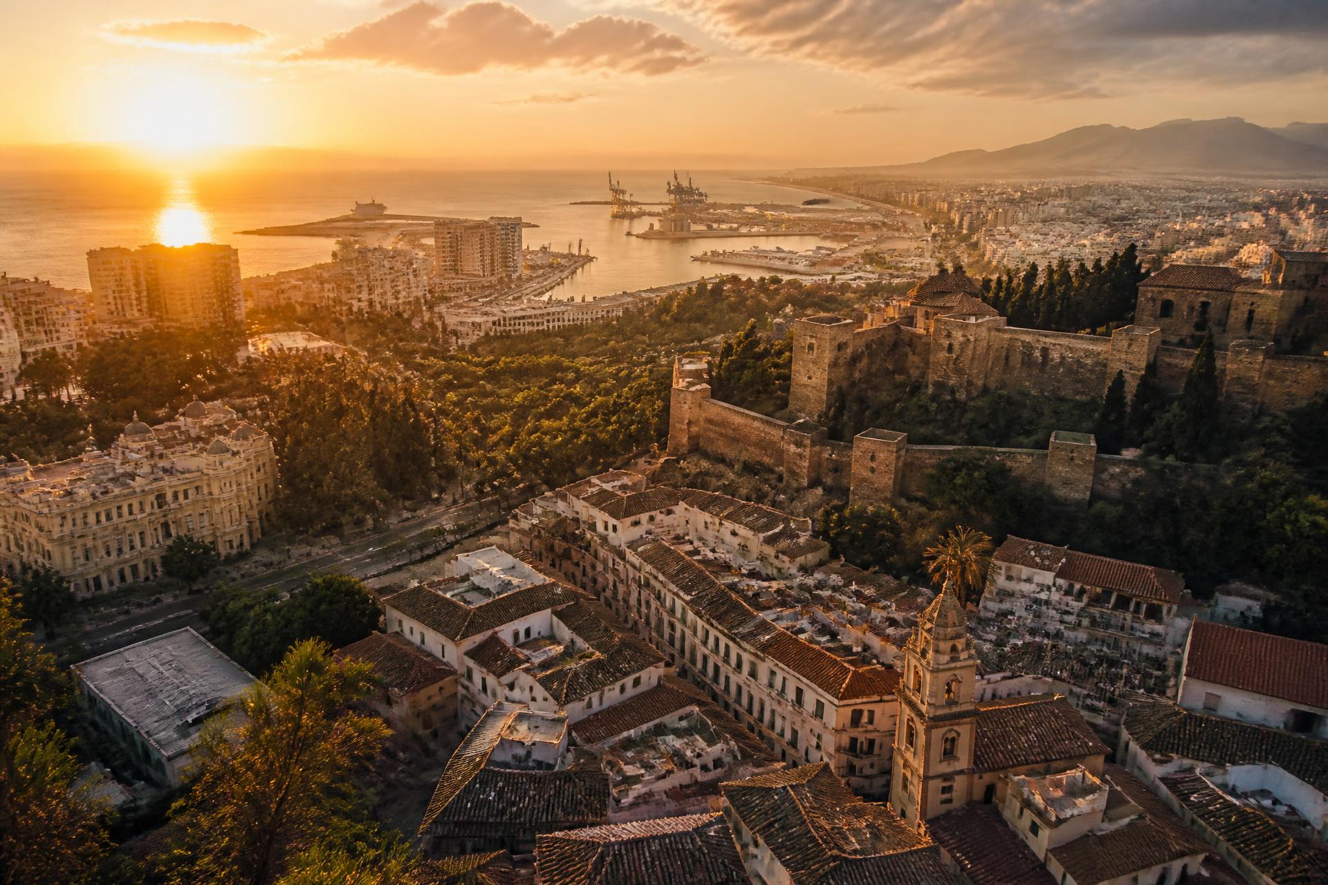 Aerial view of Málaga, Spain at golden hour with the Alcazaba fortress and Mediterranean Sea